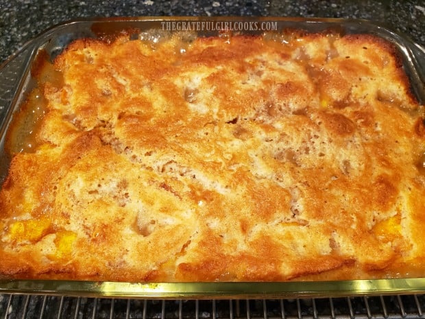 Fresh peach cobbler, straight from the oven, cooling on a wire rack.