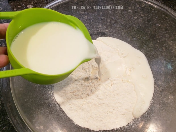 Milk is added to the sifted dry ingredients for the cobbler batter.