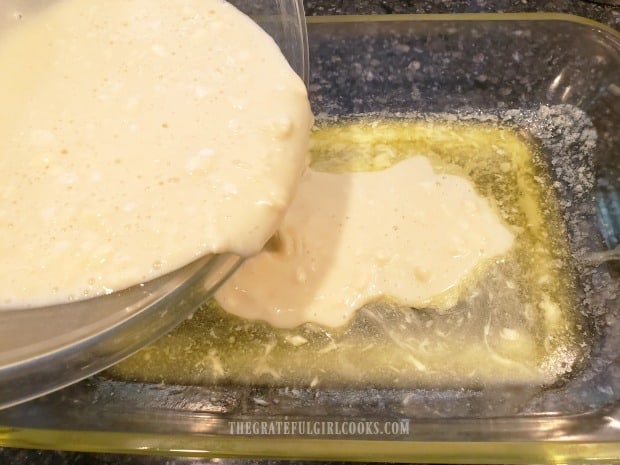 The batter is poured on top of melted butter in baking pan.