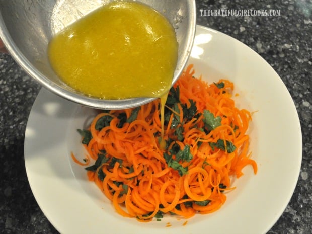 The lemon ginger salad dressing is drizzled on a spiralized carrot salad.