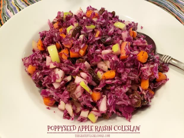 Crisp Poppyseed Apple Raisin Coleslaw, w/ purple cabbage, carrots, Granny Smith apples, & raisins, is tossed with poppyseed dressing, and served cold.