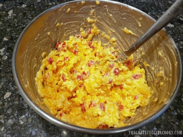 The pimiento cheese ingredients are stirred together until it forms a cheese spread.