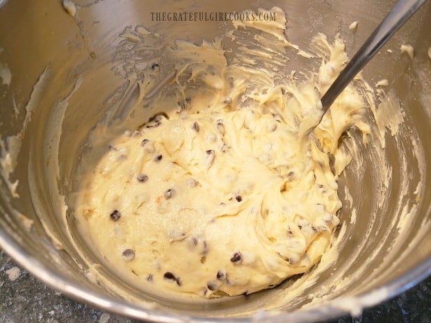 Flour, salt and chocolate chips are stirred into the cookie batter until combined.