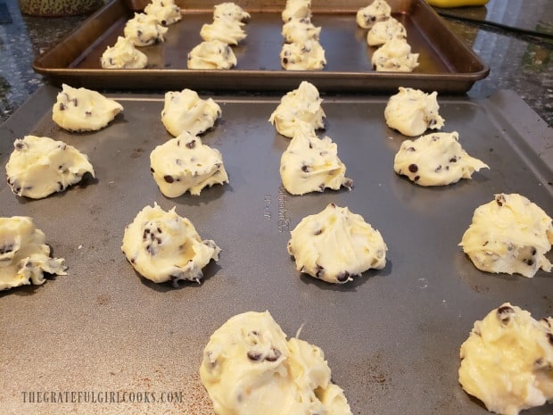 The dough for orange chocolate chip cookies are spooned onto baking sheets.