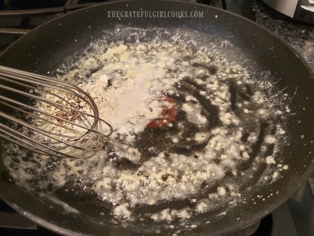 Flour, salt and pepper are whisked into garlic butter in skillet.