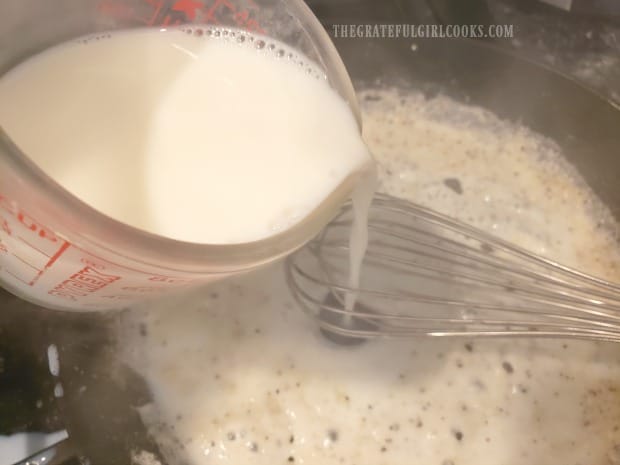 Milk is added to skillet, and whisked in, to form the creamy sauce for potatoes.