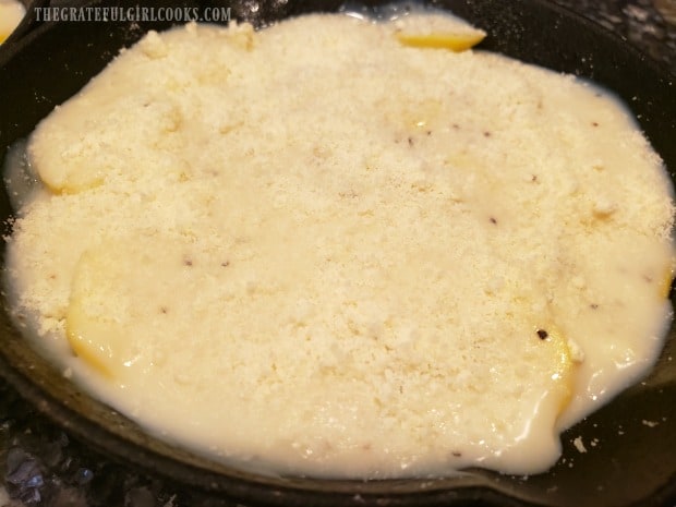 Grated Parmesan cheese is generously sprinkled over the sauce and potatoes.