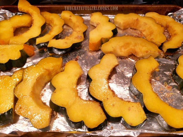 Baked Praline Acorn Squash slices are flipped after 5 minutes in oven.