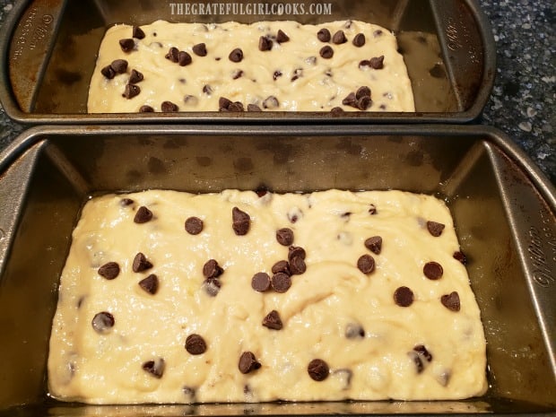 Chocolate chip banana bread batter is divided into two loaf pans for baking.