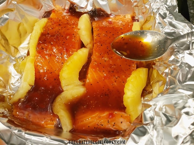 The seasoned salmon fillets are covered with a sauce before baking.
