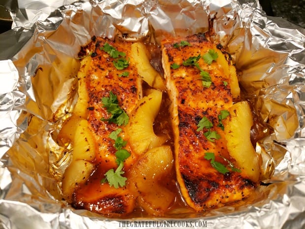 Baked then broiled salmon is garnished with chopped cilantro before serving.