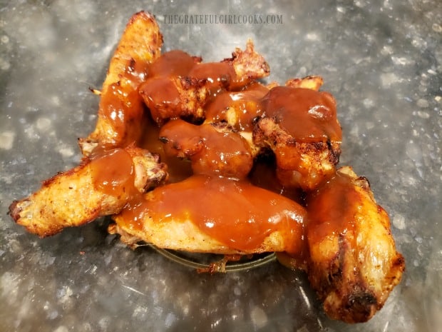 Air Fryer Buffalo Honey Wings are coated with the spicy and sweet sauce before serving.