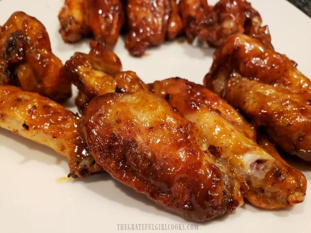 Some of the air fryer buffalo honey wings on a white plate, ready to serve and eat!