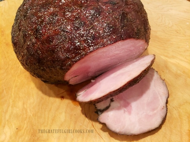 Boneless brown sugar glazed ham is sliced for serving.