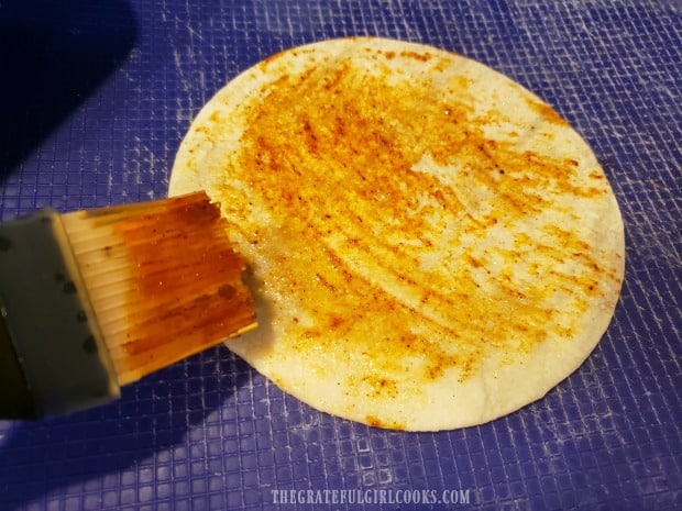 Each corn tortilla is brushed with the spicy sauce before cooking.