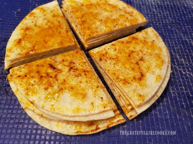 Tortillas are cut into quarters before placing them into an air fryer.