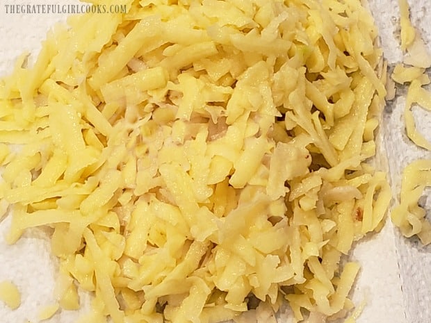 Potatoes are peeled, then grated onto paper towels.