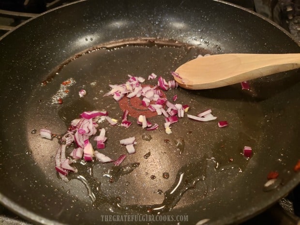 Chopped red onion is cooked in a small bit of bacon drippings.