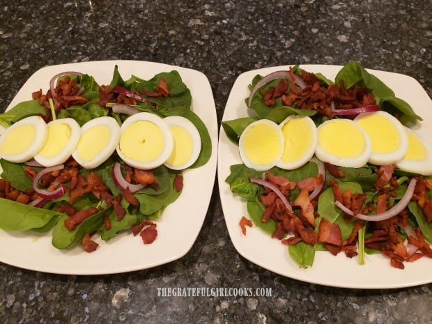 Two plates full of the Bacon Lover's Spinach Salad, before adding salad dressing.