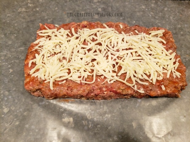 Marinara sauce and grated mozzarella cheese cover the meatloaf half.