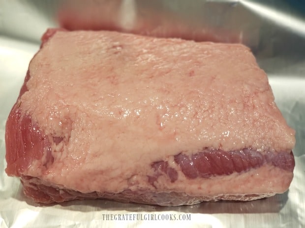 The seasoned corned beef is wrapped in foil, fat-side up.