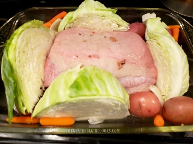 Cabbage quarters are added to the corned beef and it is baked more.