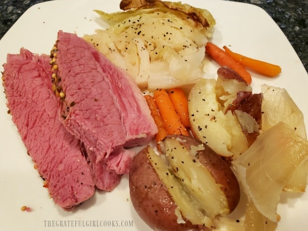 Corned beef and cabbage served with potatoes, onions and carrots.
