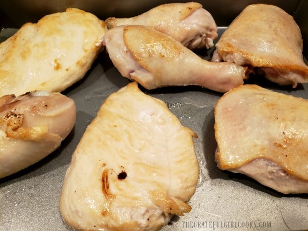 Lightly browned chicken pieces are placed in baking dish.