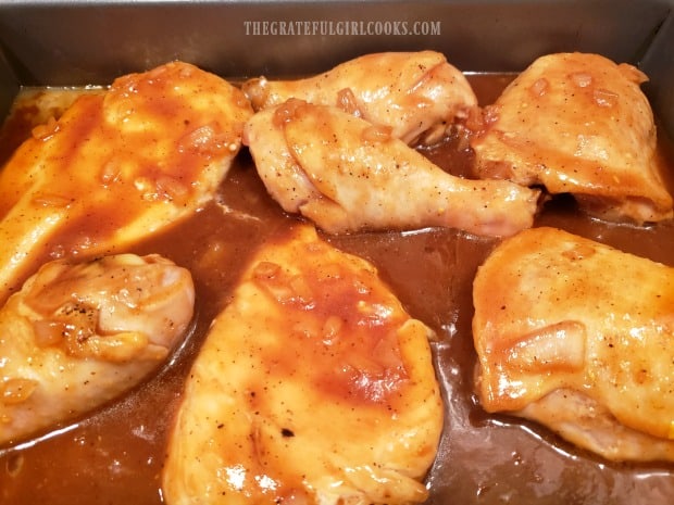 Homemade BBQ sauce is poured over chicken, to coat, before baking.