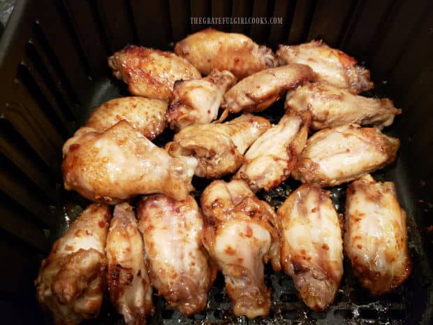 The marinated chicken wings are cooked in an air fryer.