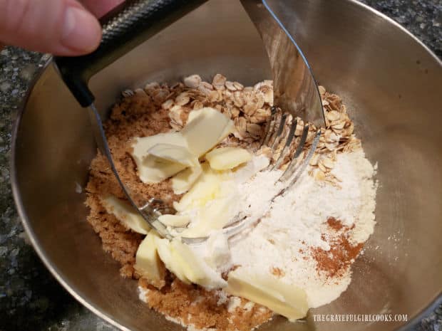 A crumb topping for the fruit crisp is mixed with a pastry blender.