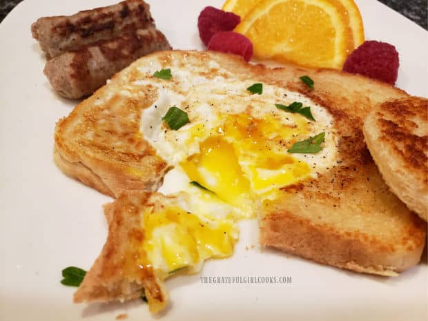 The finished egg in a basket is sprinkled with parsley and served.