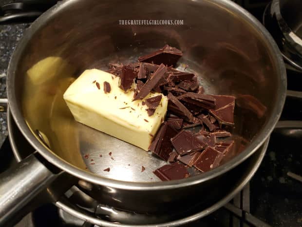 Bittersweet chocolate and butter is melted over a double boiler on stove.