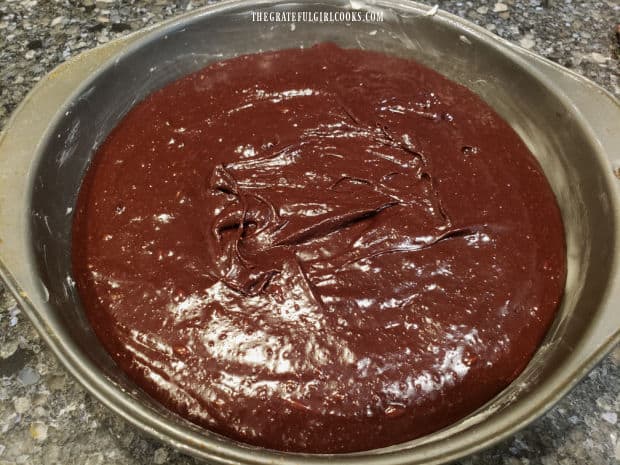 Batter for the flourless chocolate cake is spread evenly into prepared cake pan.