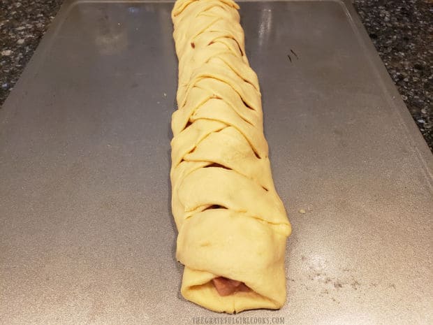 The crescent roll dough is braided together over the ham and cheese filling.