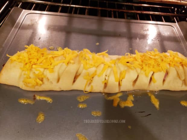 When almost finished baking, more cheddar cheese is added to the top of the braid.