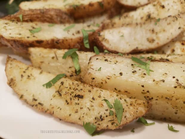 A close up of the spices on the baked Parmesan garlic potato wedges.