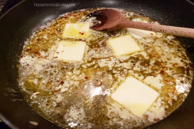 A white wine, butter, and garlic sauce cooking in skillet.