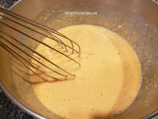 The wet ingredients are whisked for the pumpkin spice waffles batter.