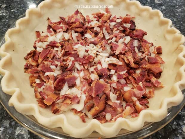 Cooked, crumbled bacon and chopped onions are added to pie shell.