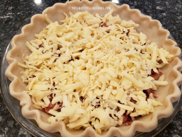 Grated Swiss cheese is added to the quiche ingredients in pie shell.