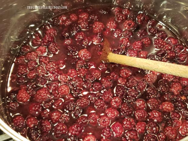 Lots of blackberries cooking in large pot to make pancake syrup.