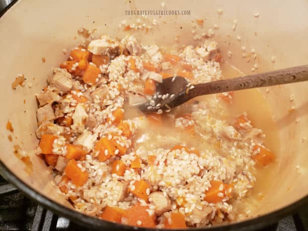 Chicken broth is added to the butternut squash risotto and cooked until it is absorbed.