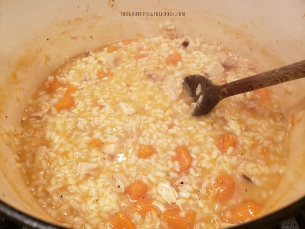 More chicken broth is added and stirred into the risotto as it cooks.