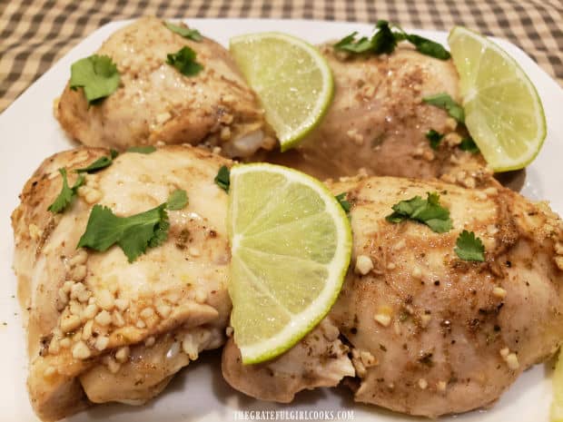 Lime slices and chopped cilantro garnish the garlic lime chicken thighs for serving.