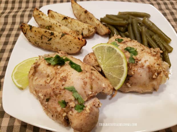 Wedge potatoes and green beans are served with two garlic lime chicken thighs.