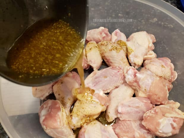 Pouring the marinade over the chicken wings before refrigerating.