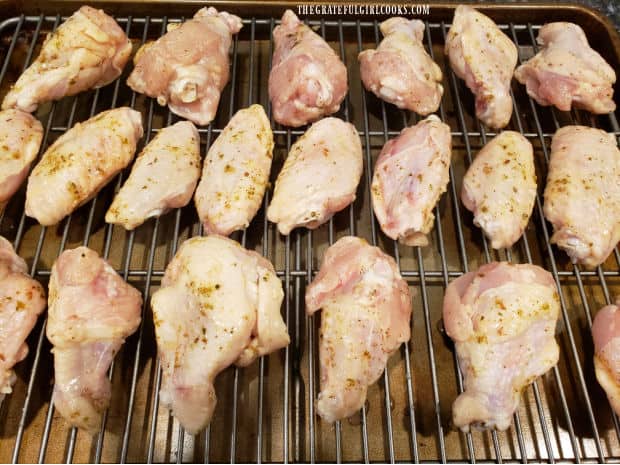 Greek-style chicken wings are baked after marinating in sauce.