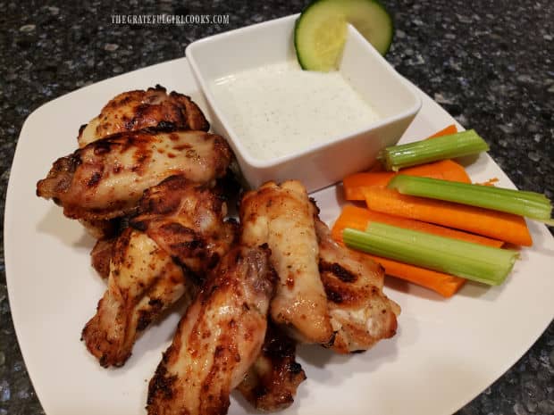 The Greek-style chicken wings are serving with dipping sauce, carrots and celery.