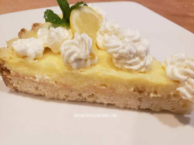 A slice of lemon cream cheese tart, served on a white plate.